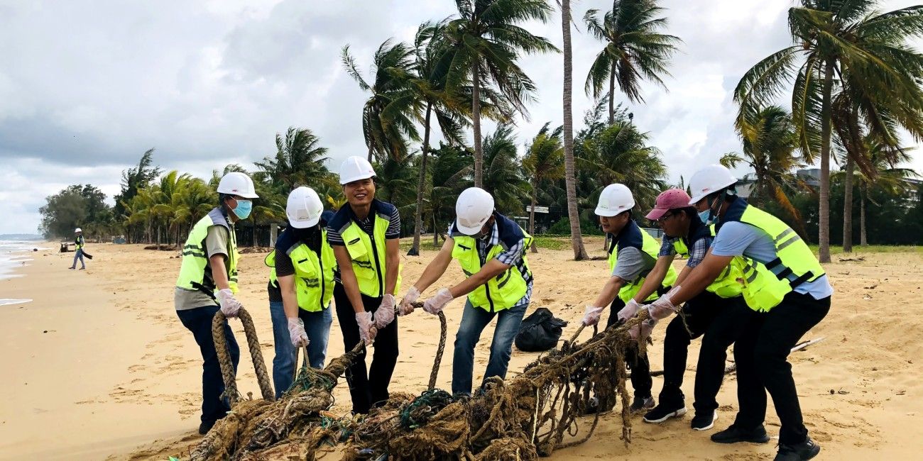 Collaborateurs ramassant des déchets sur une plage